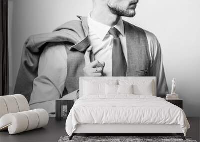 Handsome young elegant man in grey classic vest pose against studio background. Black-white photo. Wall mural