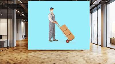 Delivery man is carry hand truck with brown cardboard and colorful background. Wall mural