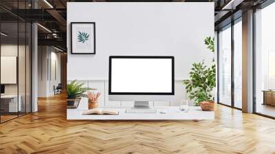 Desktop screen computer screen close up on the white desk. Vase of plant frame and book. Wall mural