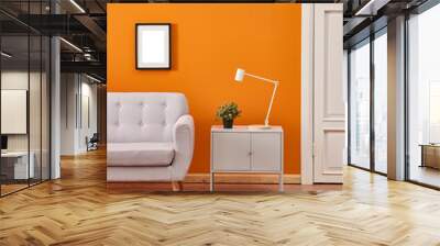 Orange wall, white classic door, grey sofa and grey cabinet, white lamp with frame vertical shoot. Wall mural