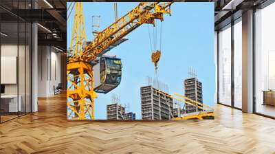 Crane and building construction site against blue sky Wall mural