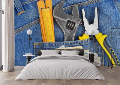 Earnings concept - money and tool in blue jeans pocket Wall mural