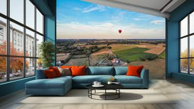 Hot air balloons in the sky of Walloon over beautiful farmland landscape. Colorful hot air balloons flying over the valley during  sunset time. Belgium Wall mural