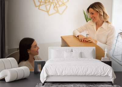 Woman in an office being attended by receptionist Wall mural