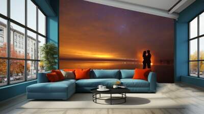 Silhouetted Couple Embracing Under a Starry Night Sky on a Beach Wall mural