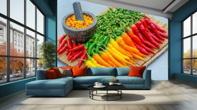 Vibrant Chilies and Mortar Preparation, a bright array of fresh chilies on bamboo, accompanied by a mortar and pestle, poised for crafting a flavorful vegetarian chili paste Wall mural