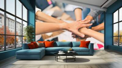 Business partners teamwork or friendship concept. Multiethnic diverse group of colleagues join hands together. Creative team, coworkers, or college students in project meeting at modern office. Wall mural