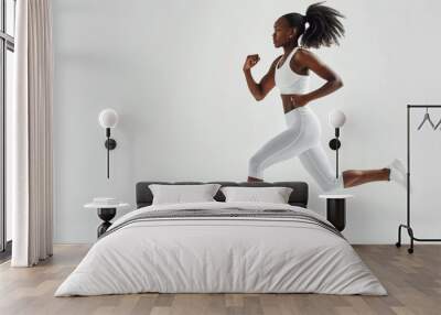 black woman wearing sport clothes running in white background Wall mural