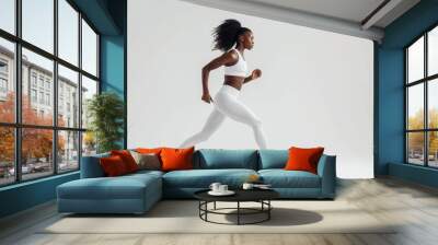 black woman wearing sport clothes running in white background Wall mural