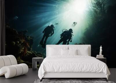 two scuba divers diving deep next to a bank of fishes Wall mural