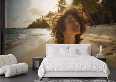 young fit woman with black curly hair on the beach Wall mural