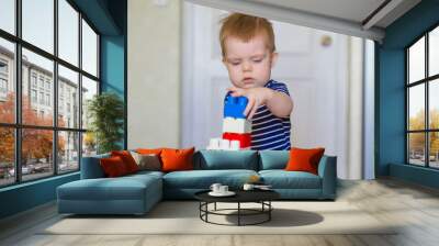 Close up of child's hands playing with colorful paints at the table. Toddler having fun and building out of bright constructor bricks. Early learning. stripe background. Developing toys Wall mural