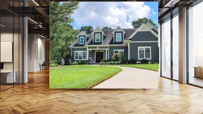 A low angle view of a large gray new construction house with a landscaped yard and leading pathway sidewalk Wall mural