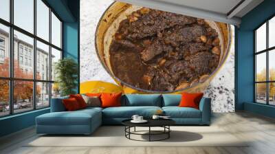 A yellow dutch oven with homemade braised beef short ribs in wine and garlic Wall mural