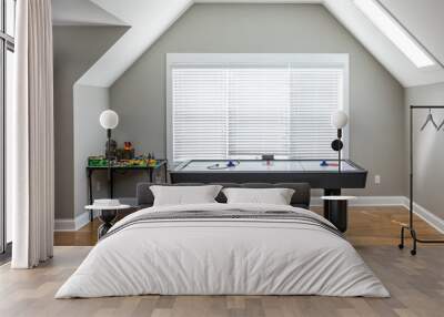 Open and airy upstairs loft game room near a window under an attic style ceiling with a window for natural light and hardwood floors Wall mural