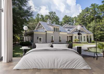 Rear view and backyard of large cape cod style home with columns and windows and a round porch patio Wall mural