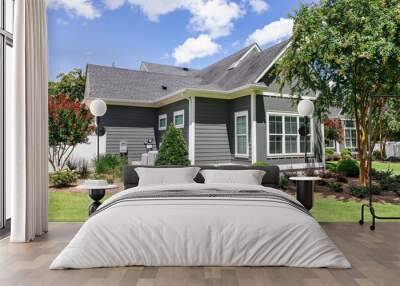 Side view of a large gray craftsman new construction house with a landscaped yard and a garage and driveway Wall mural