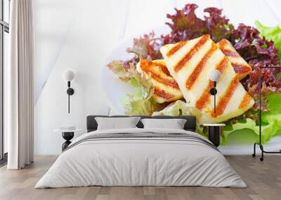 green salad with fried halloumi cheese in a white plate on a white wooden background Wall mural