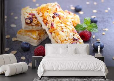 healthy snack, muesli bars with raisins and dried berries on a black background Wall mural