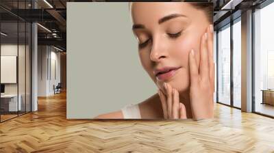 Beauty healthy skin woman touching her face beautiful female. Color background. Green Wall mural