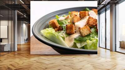 A close-up of a Caesar salad with grilled chicken, croutons, and creamy dressing. Wall mural