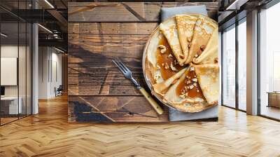 crepes with salted caramel and nuts, top view, wooden background, copy space Wall mural