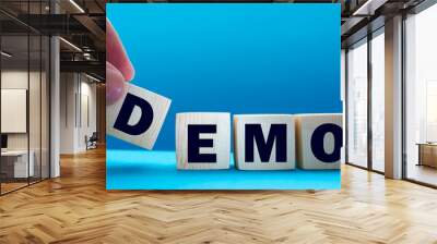 Demo symbol. Concept word 'demo' on cubes on a beautiful dark wooden background. Businessman hand. Business and demo concept. Copy space. Wall mural