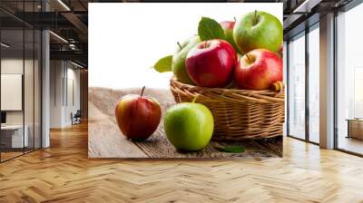 Red and green apples in basket on rustic wood table Wall mural