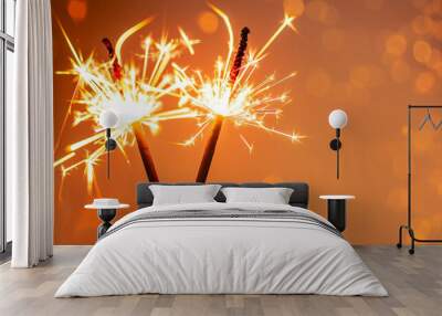 two burning sparklers with shiny lights at the edge of modern abstract orange background, graphical miracle candles party concept with copy space for happy new year, christmas and other holidays Wall mural