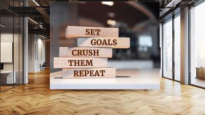 Wooden blocks with words 'Set goals crush them repeat'. Wall mural