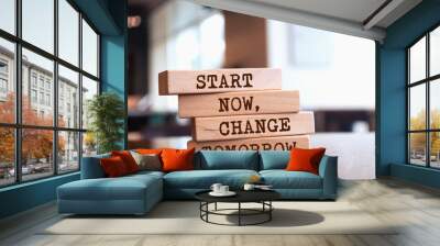 Wooden blocks with words 'Start now, change tomorrow'. Wall mural