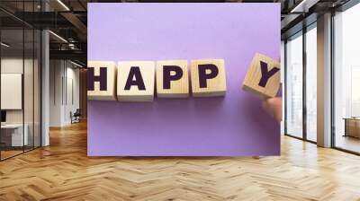 Wooden cubes with word HAPPY. Wooden cubes on a pink background. Wall mural