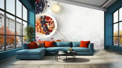 Healthy breakfast ingredients on grey concrete background, flatlay. Bowl of oat flakes with milk, fresh berries, nuts and fruits. Top view, copy space Wall mural