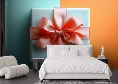 A gift box with a ribbon on the top, against a vibrant background, in a top-down view Wall mural