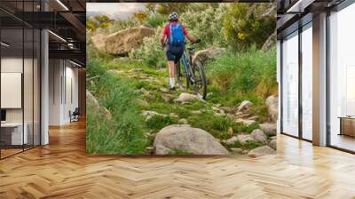 active senior woman cycling with her electric mountain bike in the rough landscape of National Parc Serra de São Mamede near Marvao in central Portugal, Europe
 Wall mural