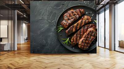 Photo of grilled steaks on a plate over a dark background with copy space, top view Wall mural