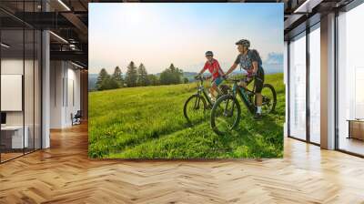 two senior girlfriends having fun during a cycling tour in the Allgau Alps near Oberstaufen, Bavaria, Germany Wall mural