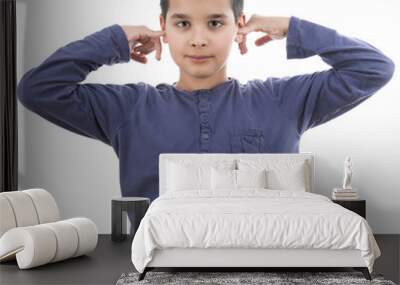 Cute boy closing his ears not hear isolated on white Wall mural