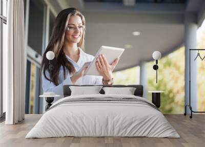 Smiling businesswoman using electronic tablet outside Wall mural