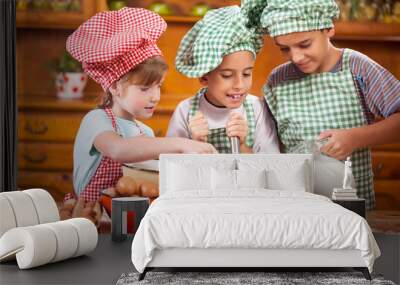 Three young child preparing ingredients for cookies in  kitchen Wall mural