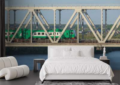 green electric locomotive passing the bridge over the river in s Wall mural