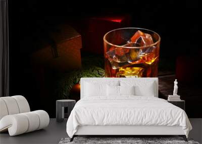 Glass with cognac or whiskey, Christmas balls and candles. New Year's tree, balls and glass with alcohol. Wall mural