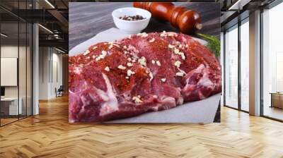 Raw pork steaks on wooden board with herbs, spices, tomatoes and pepper grinder ready for cooking. Selective focus Wall mural