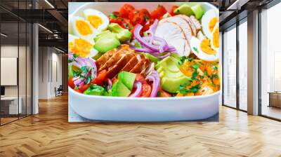 American cobb salad with chicken, avocado, egg, tomatoes and onions in white dish, light background. American cuisine concept. Wall mural