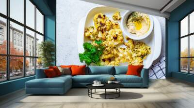 Baked cauliflower in white dish with hummus. Healthy food concept. Wall mural