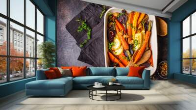 Baked vegetables with thyme in the oven dish, dark background. Wall mural