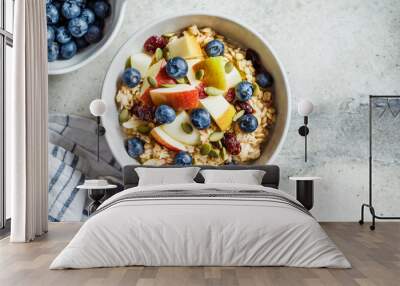 Bircher muesli or overnight oatmeal with apple, banana and blueberries in gray bowl, top view. Wall mural