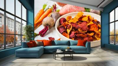 Bowl of healthy vegetable chips from beets, sweet potatoes and carrots on white background. Wall mural