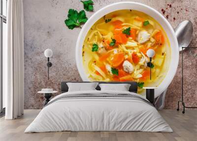 Chicken noodle soup with parsley and vegetables in a white plate, top view. Wall mural