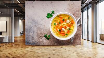 Chicken noodle soup with parsley and vegetables in a white plate, top view. Wall mural